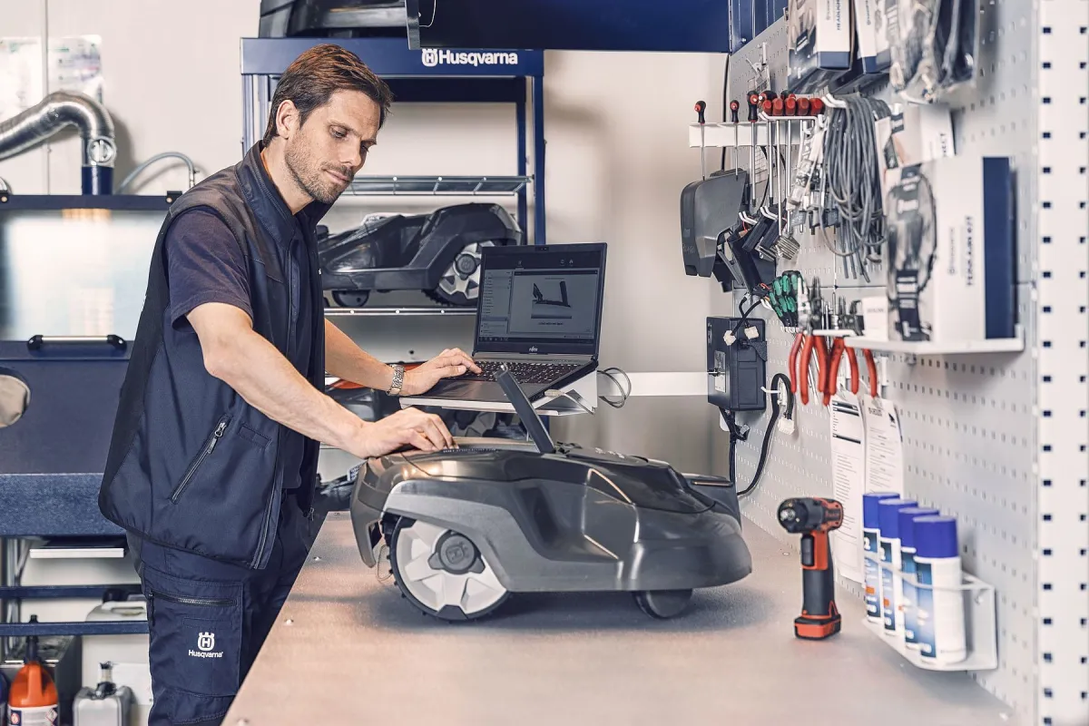 Technicus onderhoudt een Automower in de werkplaats